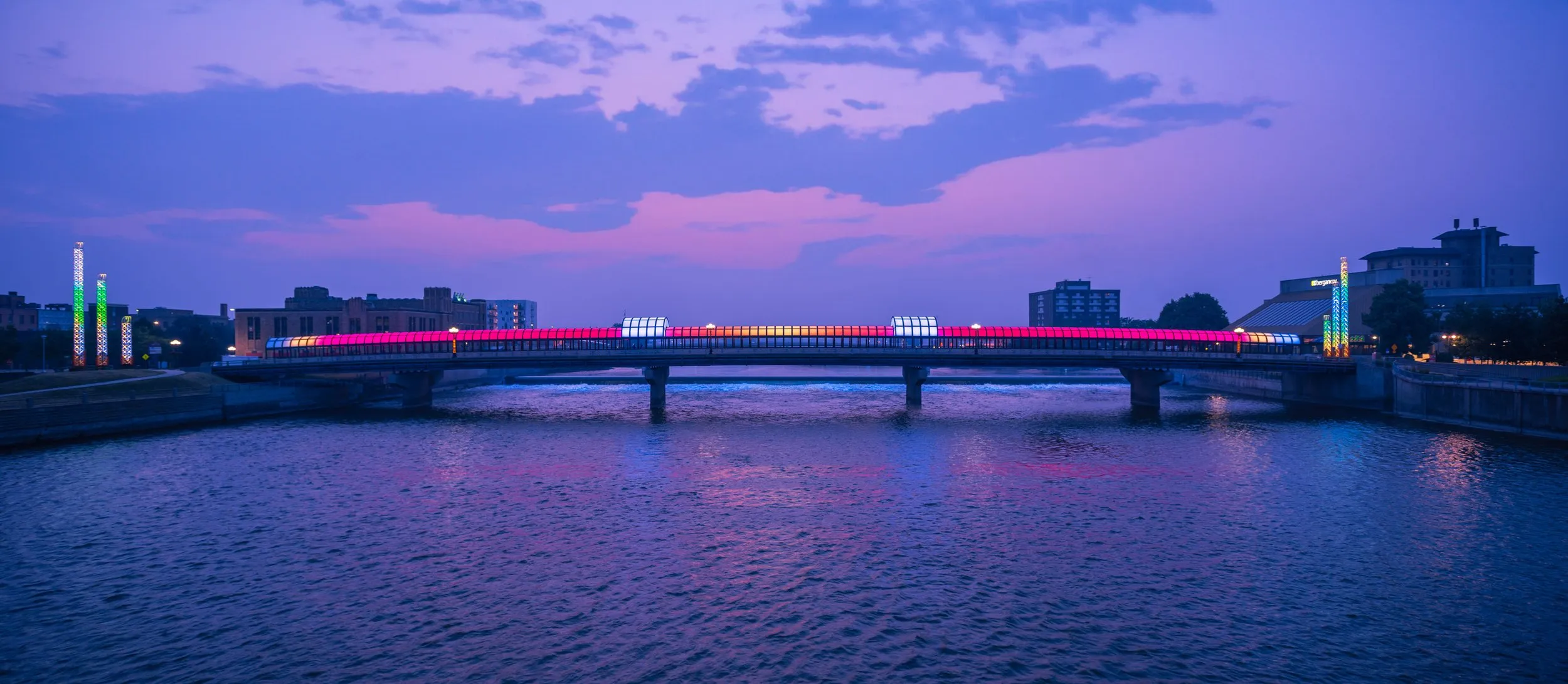 Bridge lit in blue and magenta reflected in the river at dusk, Des Moines