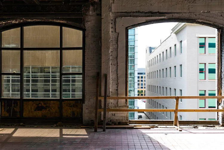 Arched industrial window framing a building across the street