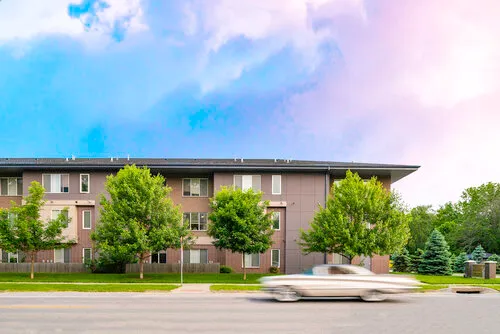Franklin Field senior apartments at evening with a vintage car