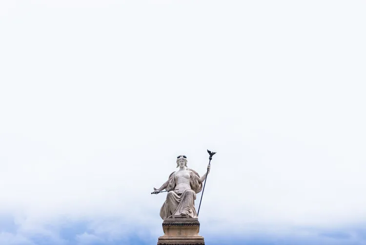 Statue silhouetted against a pale sky