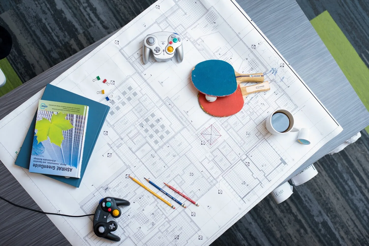Overhead flat lay of notebooks, coffee and drafting tools